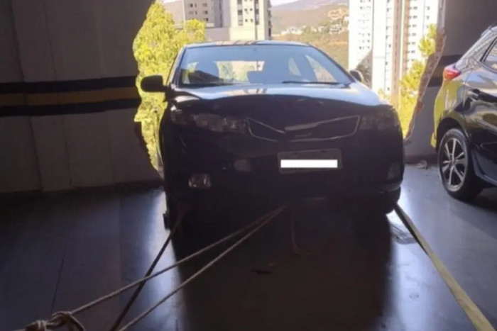Carro fica pendurado após romper fachada de estacionamento em condomínio na Grande BH