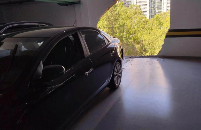 Carro fica pendurado após romper fachada de estacionamento em condomínio na Grande BH