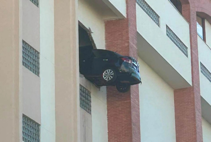 Carro fica pendurado após romper fachada de estacionamento em condomínio na Grande BH